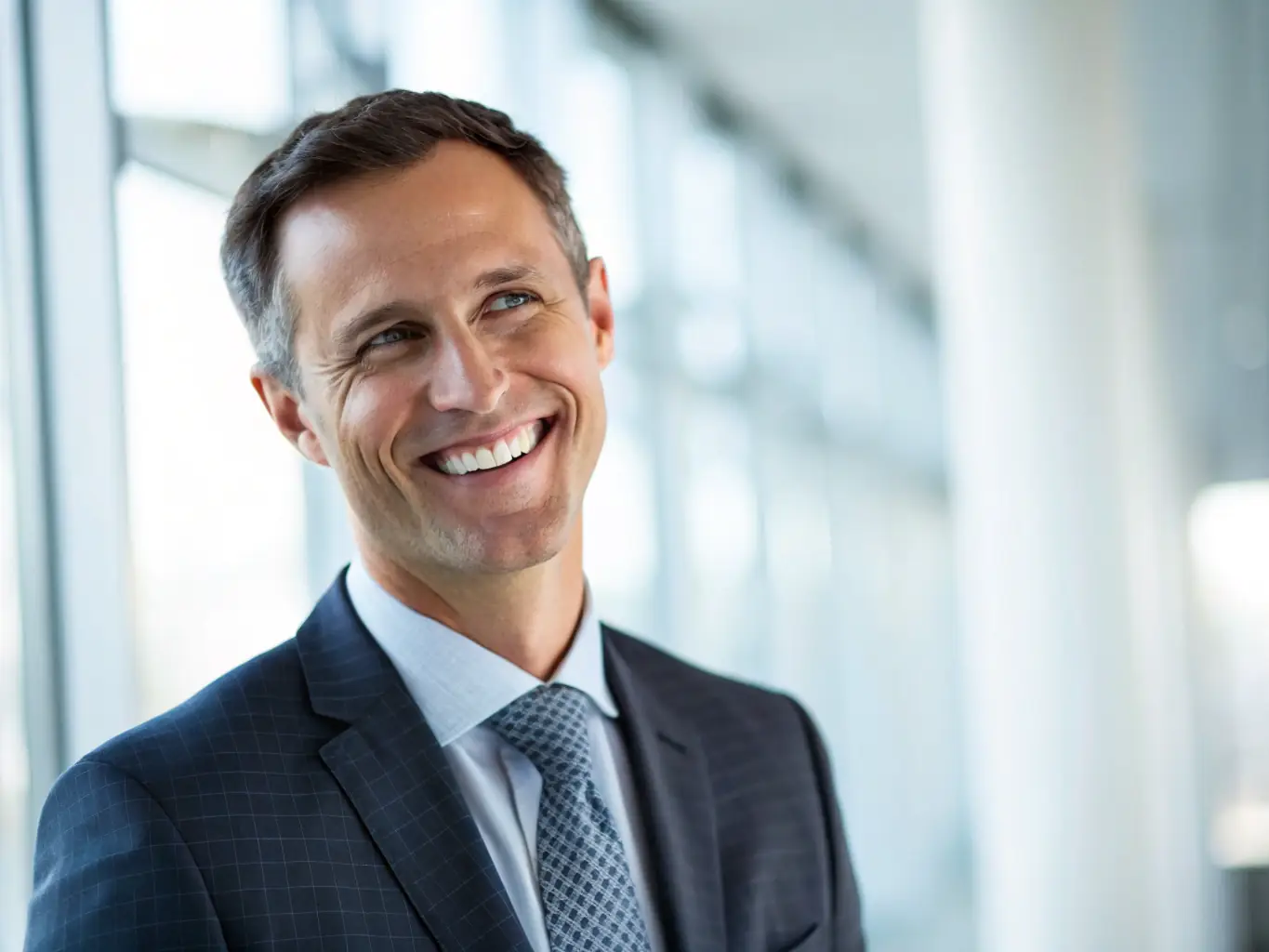 A professional headshot of a man, Mr. Ben Carter, in a suit, looking directly at the camera with a friendly expression. The background is a modern office setting.